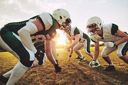 Young football players facing each other in formation.