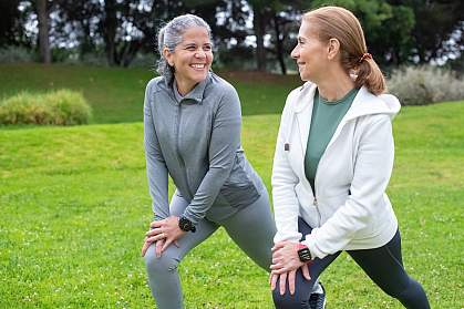 Women stretching together in a park.