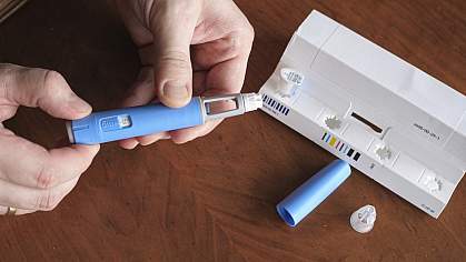 Closeup of hands preparing a semaglutide injection.