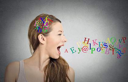 Side view portrait of a woman talking with alphabet letters in her head and coming out of her open mouth.