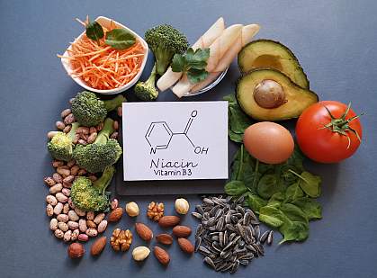 Foods rich in vitamin B3, or niacin, surround a drawing of a niacin molecule: avocado, nuts, spinach, bean, broccoli, egg, tomato, and chicken breast slices.