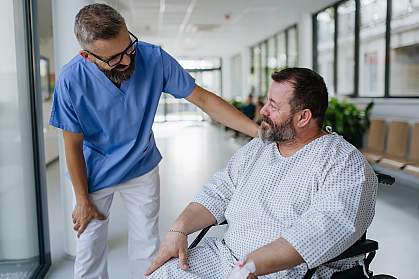 Doctor talking with an overweight patient in a wheelchair.