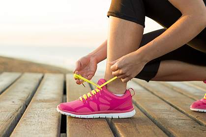 Woman tying her running shoe laces.