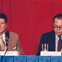 Two men sitting on a dais.