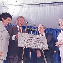 Two men and two women pose around a dedication plaque.