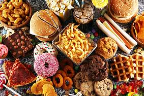 Image of many types of ultra-processed foods, including fries, hot dog, donuts, candy, soda, etc