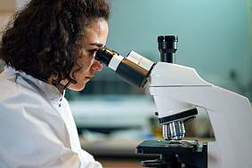 Female researcher using a microscope.