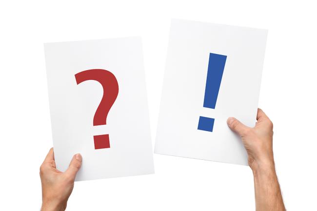 Hands holding up two cards - one displaying a large question mark and the other an exclamation mark