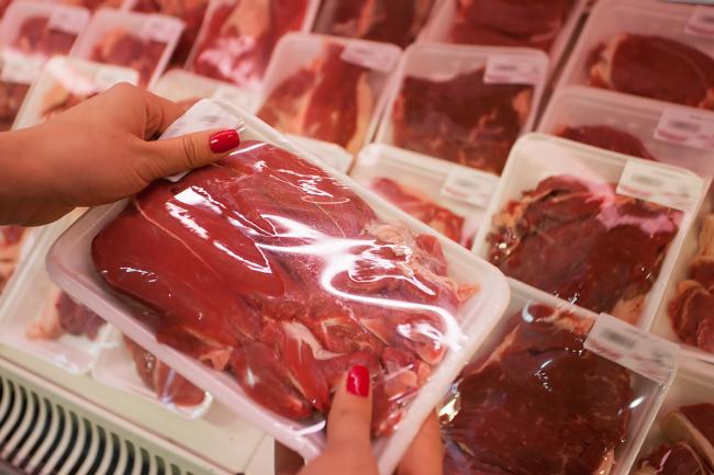 20180107-red-meat.jpg Woman holding packaged meat in the supermarket.
