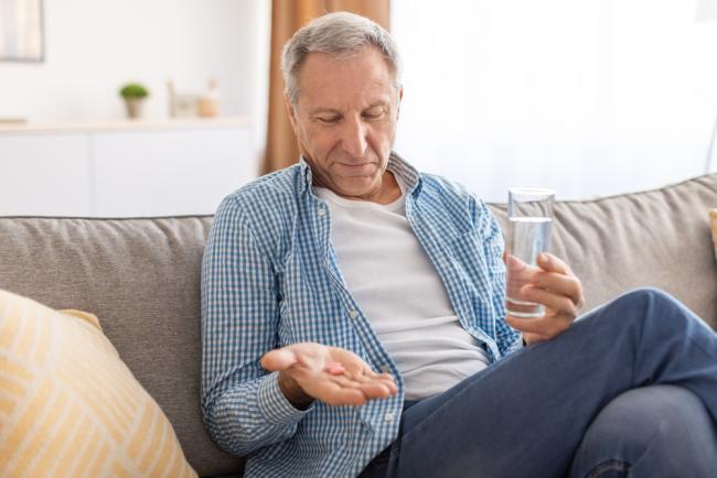 20230613-memory.jpg A older man taking a multivitamin