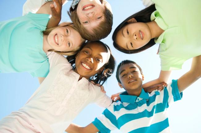 Image of diverse children arm and arm.