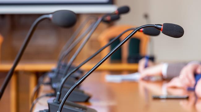 Close up the conference microphones on the table in the meeting room.
