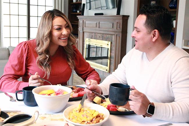 two people eating breakfast together at a kitchen table