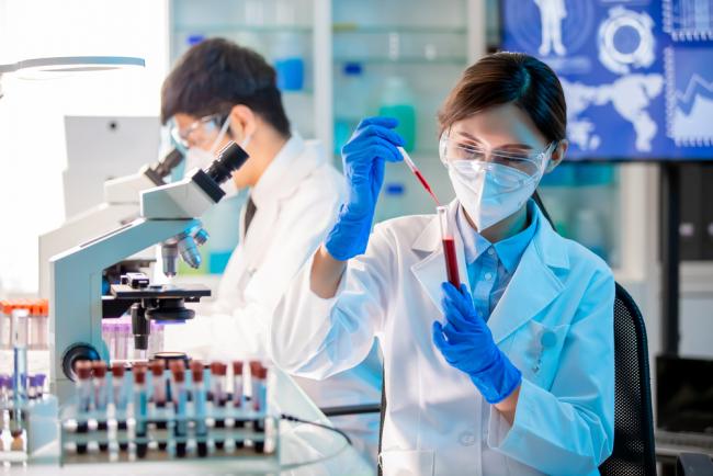Research technician fills a test tube with blood before the sample is analyzed.