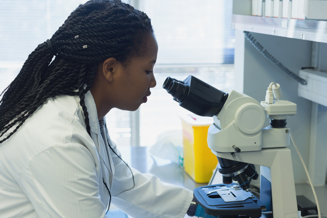Scientist analyzing samples with microscope