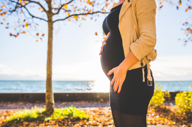 Pregnant woman holding her belly.