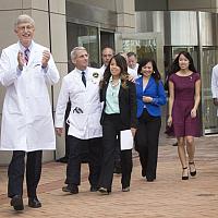 hoto of Francis Collins, Anthony Fauci and Nina Pham leaving the Clinical Center