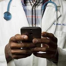 A doctor holding a cell phone.