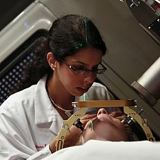 A radiation oncologist (female) and physicist (male) check a patient's positioning before stereotactic radiosurgery using a linear accelerator (LINAC).