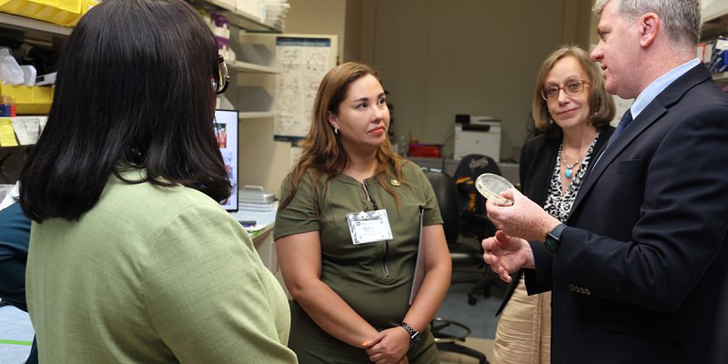 NCI’s Dr. Jack Shern, head of the Pediatric Oncology Branch’s (POB) tumor and evolution and genomics section (right) and Chief of NCI’s POB, Dr. Brigitte Widemann (second from right), discuss the unique challenges of childhood cancer with Rep. Yadira Caraveo (center), and Rep. Terri Sewell (left).