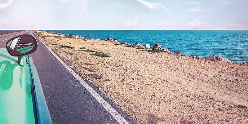 汽车高速公路旁边的海滩上的照片