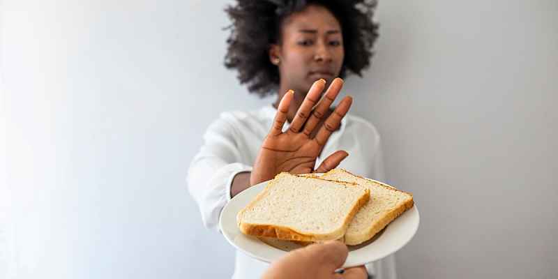 A woman refusing a plate of bread.