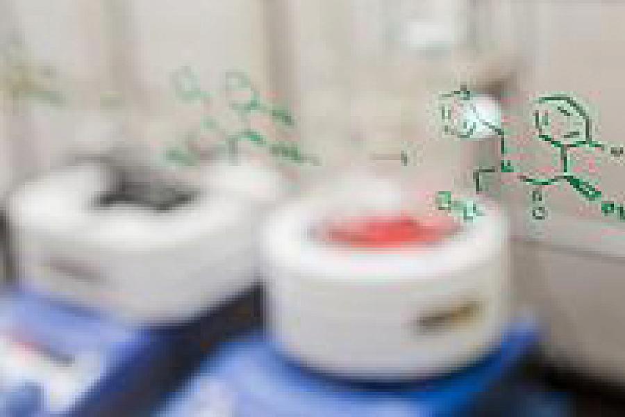 Chemical structures drawn on a glass pane in front of lab equipment