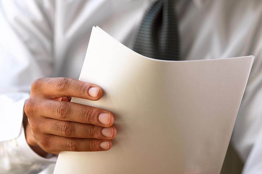 Close-up of a business man holding a stack of papers
