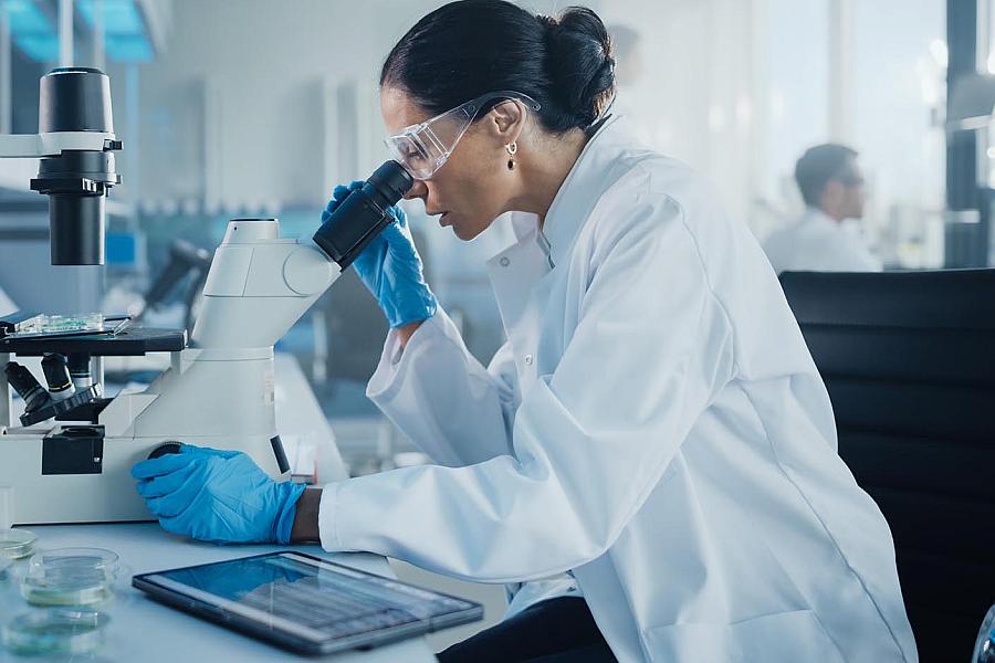 Image of a researcher looking into a microscope in a scientific lab