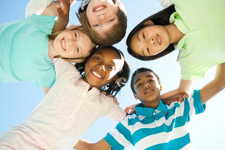 Image of diverse children arm and arm.