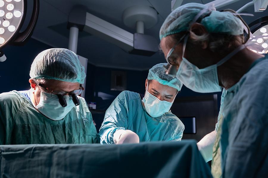 Open heart surgery, doctors and cardiologists perform open heart surgery. Doctors in green uniforms in the operating room. 