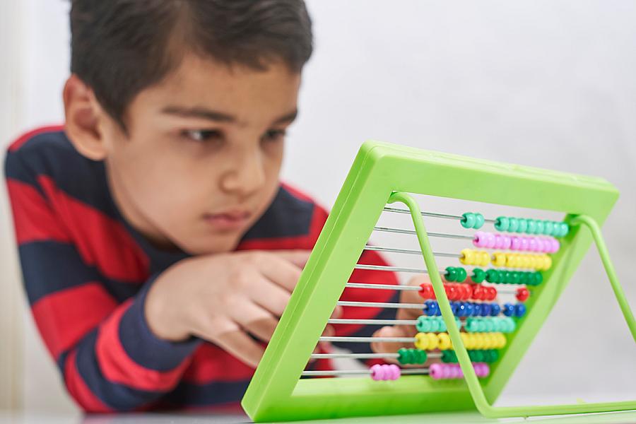 Boy focused on working with an abacus.