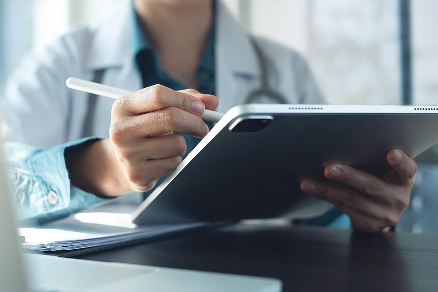 Image of a medical professional using a tablet and a stylus 
