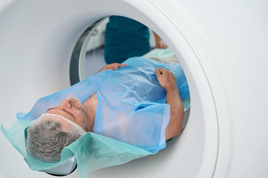 Man undergoing an abdominal CT scan in a clinic.