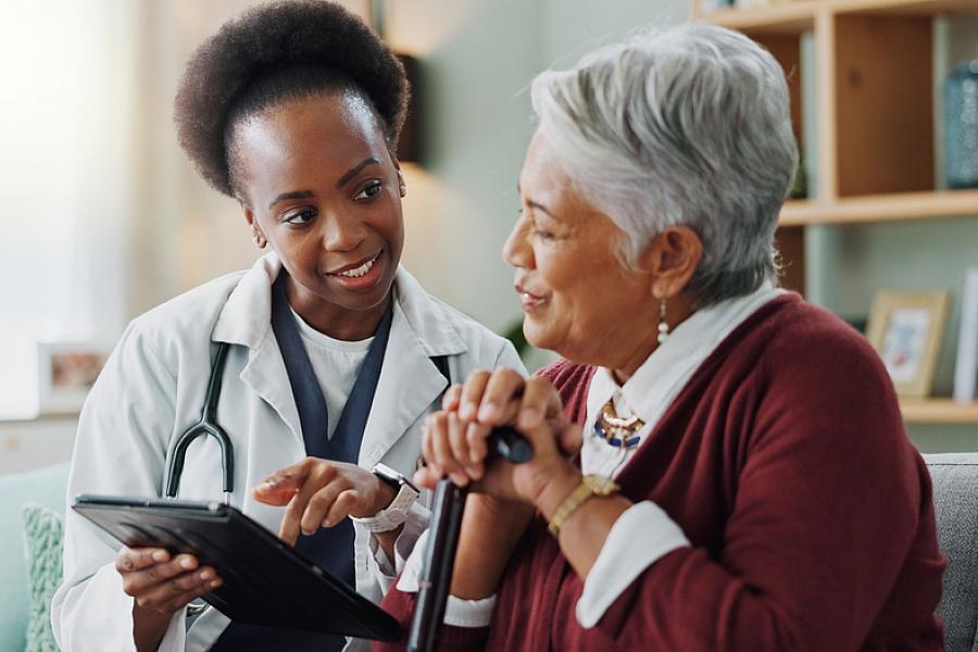 Older woman and doctor discuss medical report. 