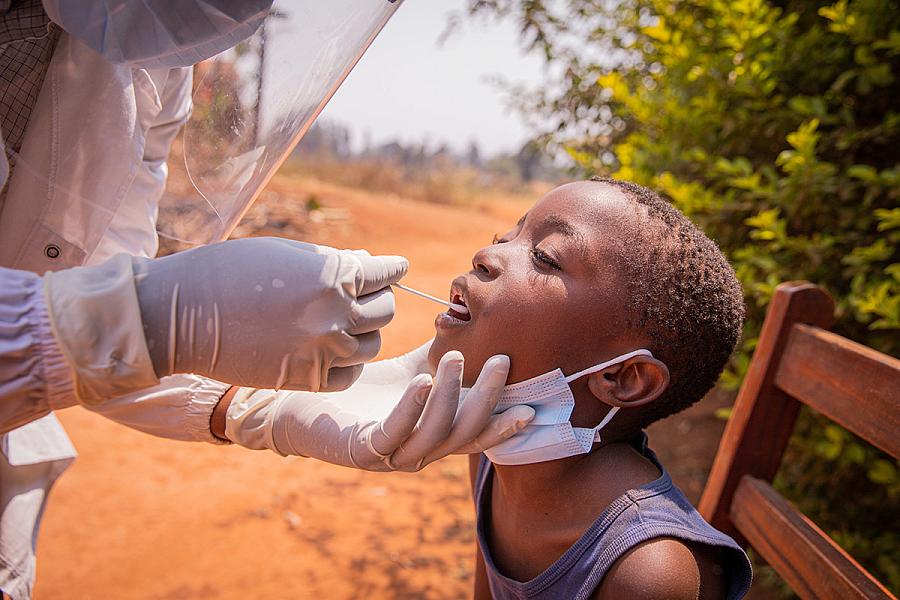 Young African child getting a tongue swab test.