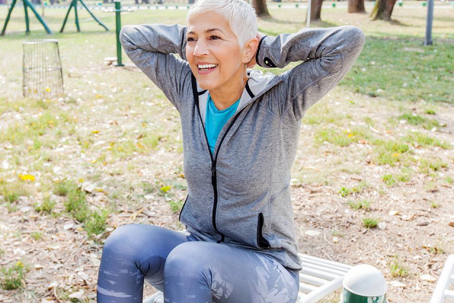 Woman exercises at an outdoor gym. 
