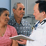 Photo of a doctor speaking with a couple.