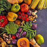 An array of fruits and vegetables on a dark surface