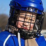 A young boy wearing sports equipment.