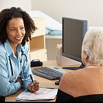  Female doctor talking to a senior woman.