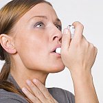Woman using an inhaler.
