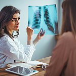 A doctor reviewing a chest X-ray with a patient