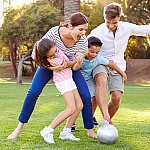 A family playing soccer outdoors