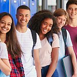 A group of teenagers standing in front school lockers