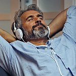 A mature man relaxing with headphones on