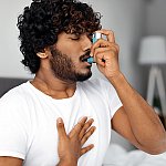 A man using an asthma inhaler