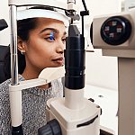 A woman getting her eyes examined with a slit lamp
