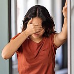 A woman holding her head from lightheadedness or dizziness