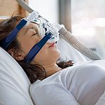 A woman sleeping with a continuous positive airway pressure (CPAP) mask on